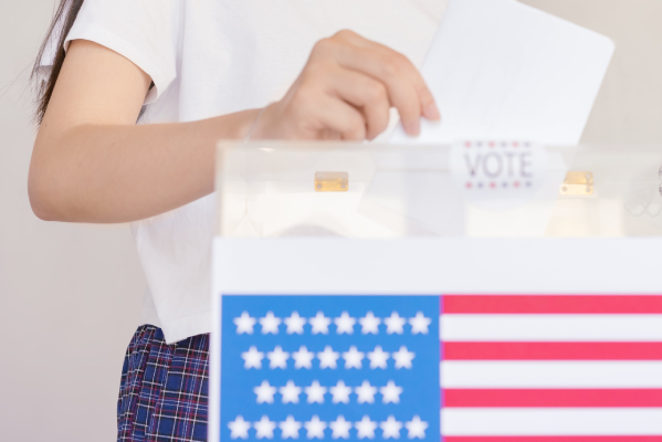 A person holding an envelope with stars and stripes on it.